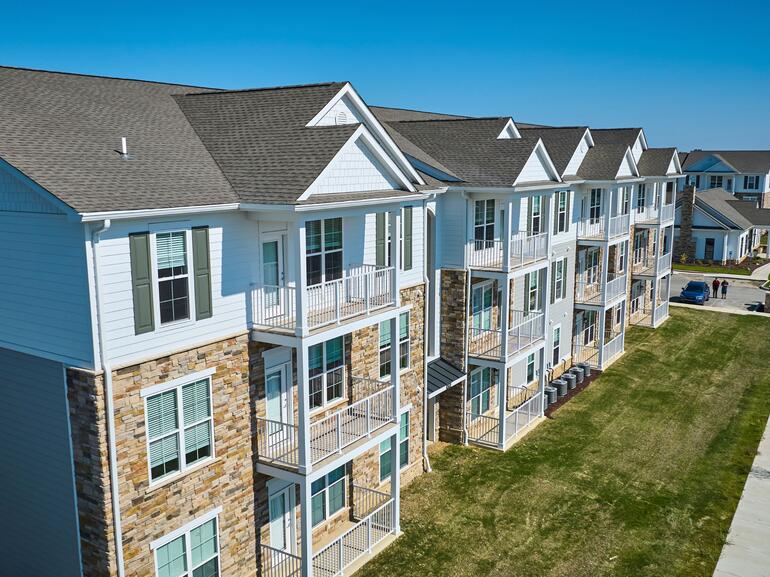 Aerial View of Sunny Modern Apartment Complex with Landscaped Lawn