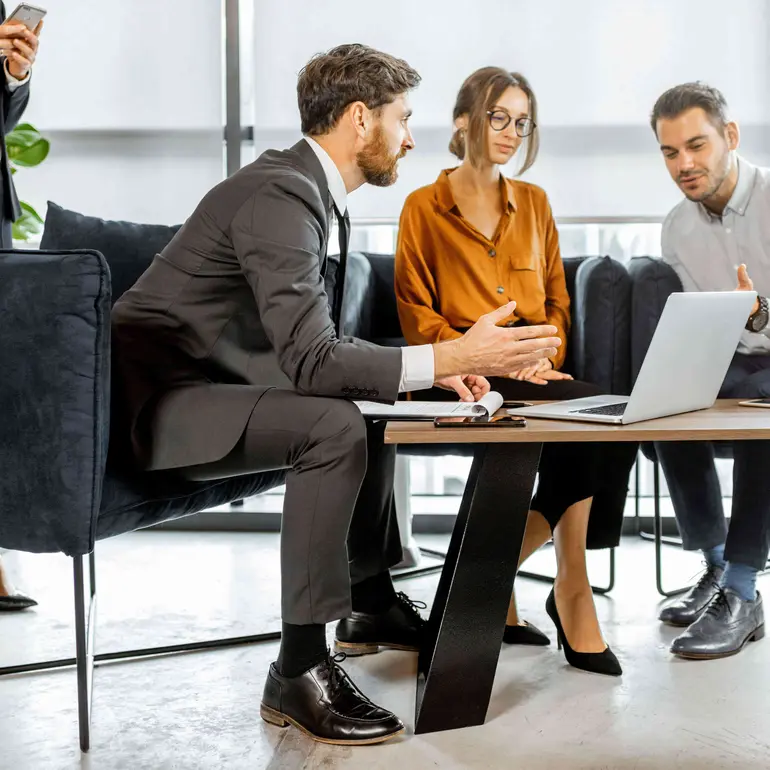three people looking at a laptop discussing their loan servicing portfolio
