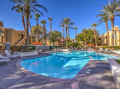 Apartment pool surrounded by palm trees,