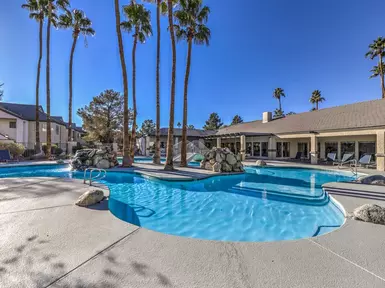 Community pool with palm trees in the background.