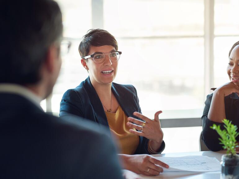 Talking, people and businesswoman in meeting, discussion or group conversation for investment. Teamwork, paperwork or financial investors planning for strategy, feedback report or project funding