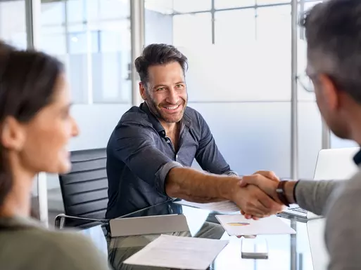 Mortgage broker shaking hands with clients