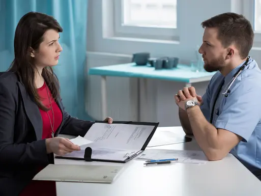 Physician speaking with his accountant, lawyer or other advisor in a medical office setting